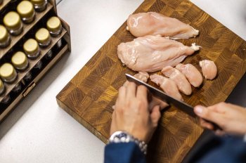 Мужчина нарезает куриное филе