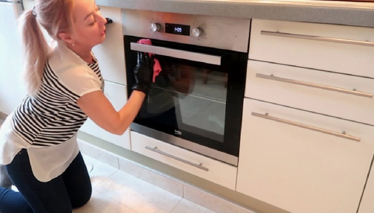женщина чистит духовку