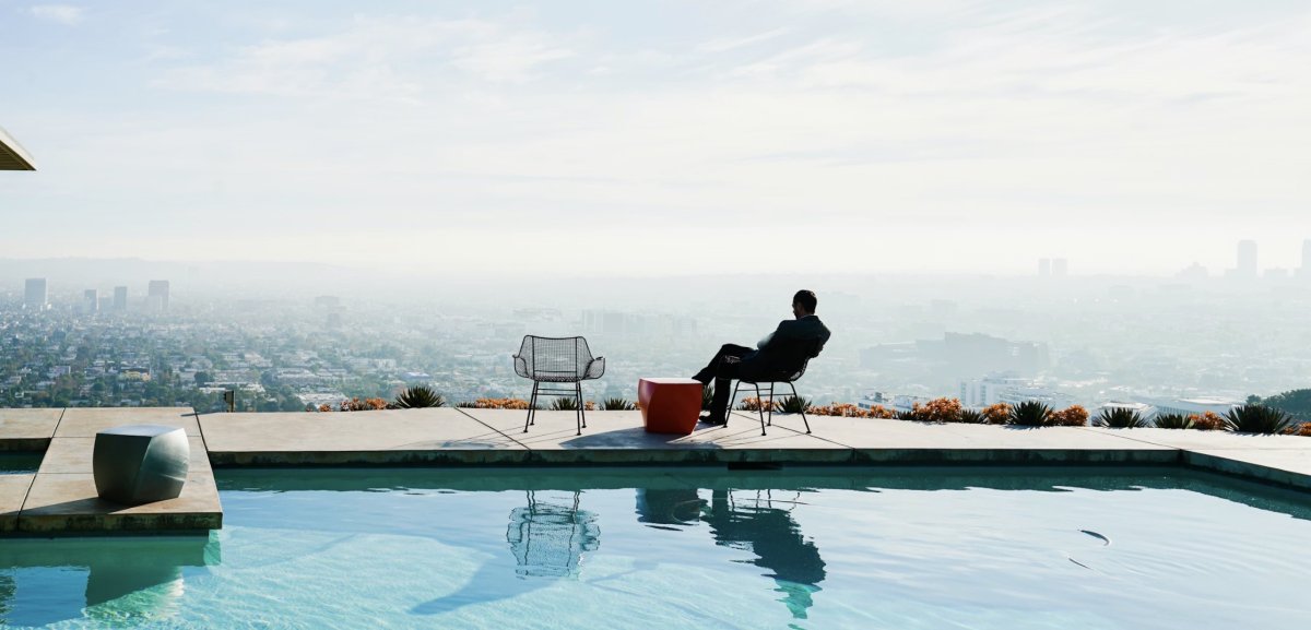 Мужчина сидит возле бассейна