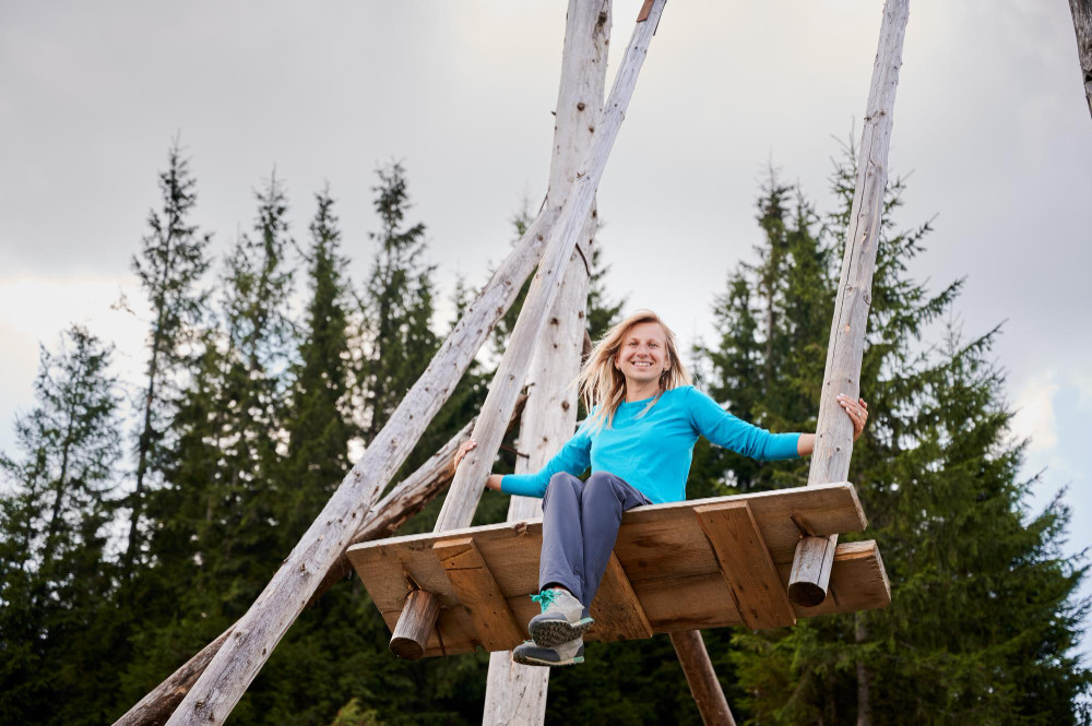Девушка качается на гигантских качелях.