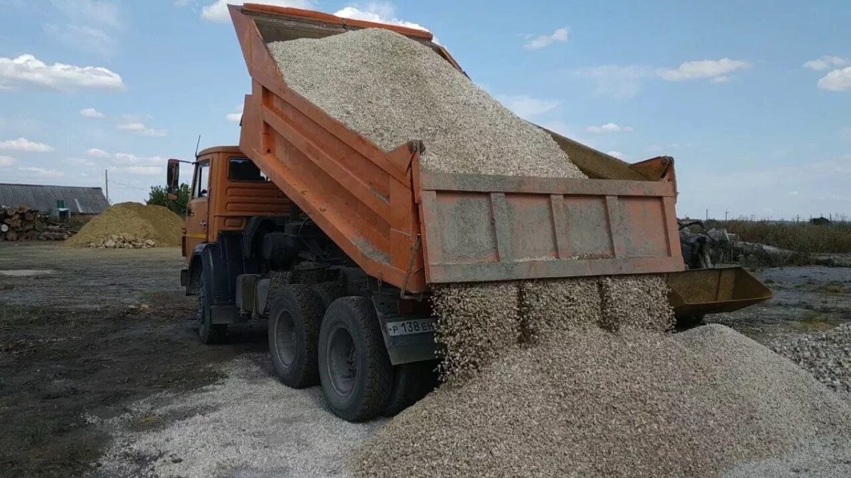 КамАЗ выгружает отсев на участок