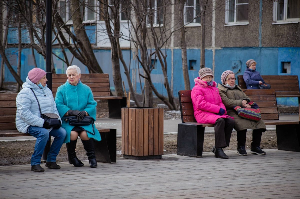 Пенсионеры сидят на улице.