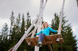 Девушка качается на гигантских качелях.